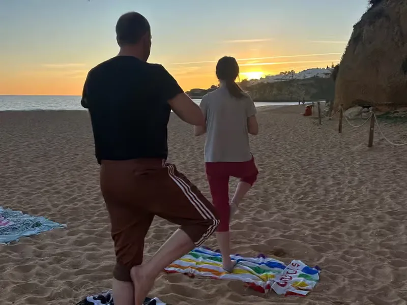People practicing yoga at the beach in Albufeira during sunset