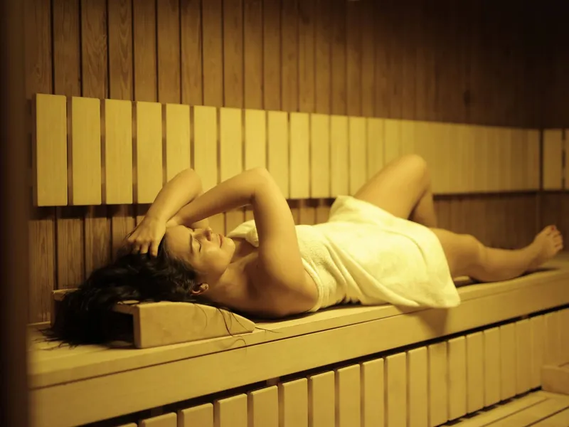 A relaxing woman in a sauna at a peaceful spa in Albufeira.