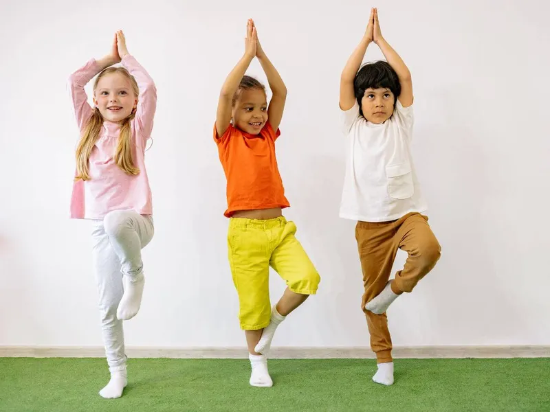 A child practicing animal-inspired yoga poses during a kids yoga session near the beach in Albufeira.