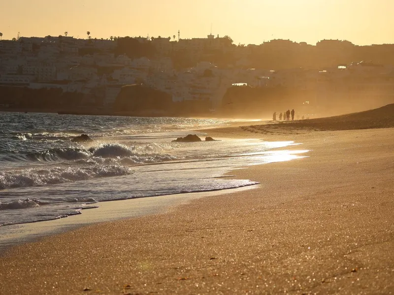 Participant practicing sunset breathwork in Albufeira while sitting on the sandy beach facing the ocean.