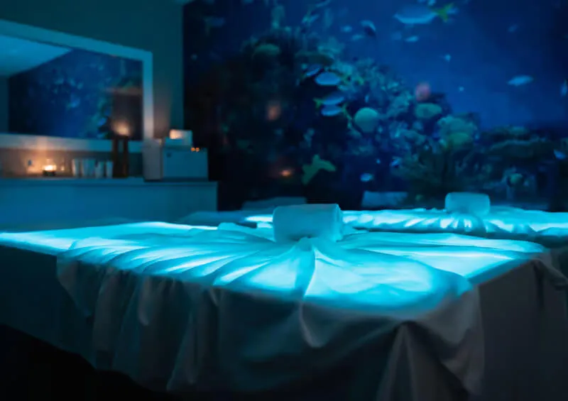 A calm, softly lit spa room featuring a warm water mattress prepared for an essential oil massage on Terceira Island.