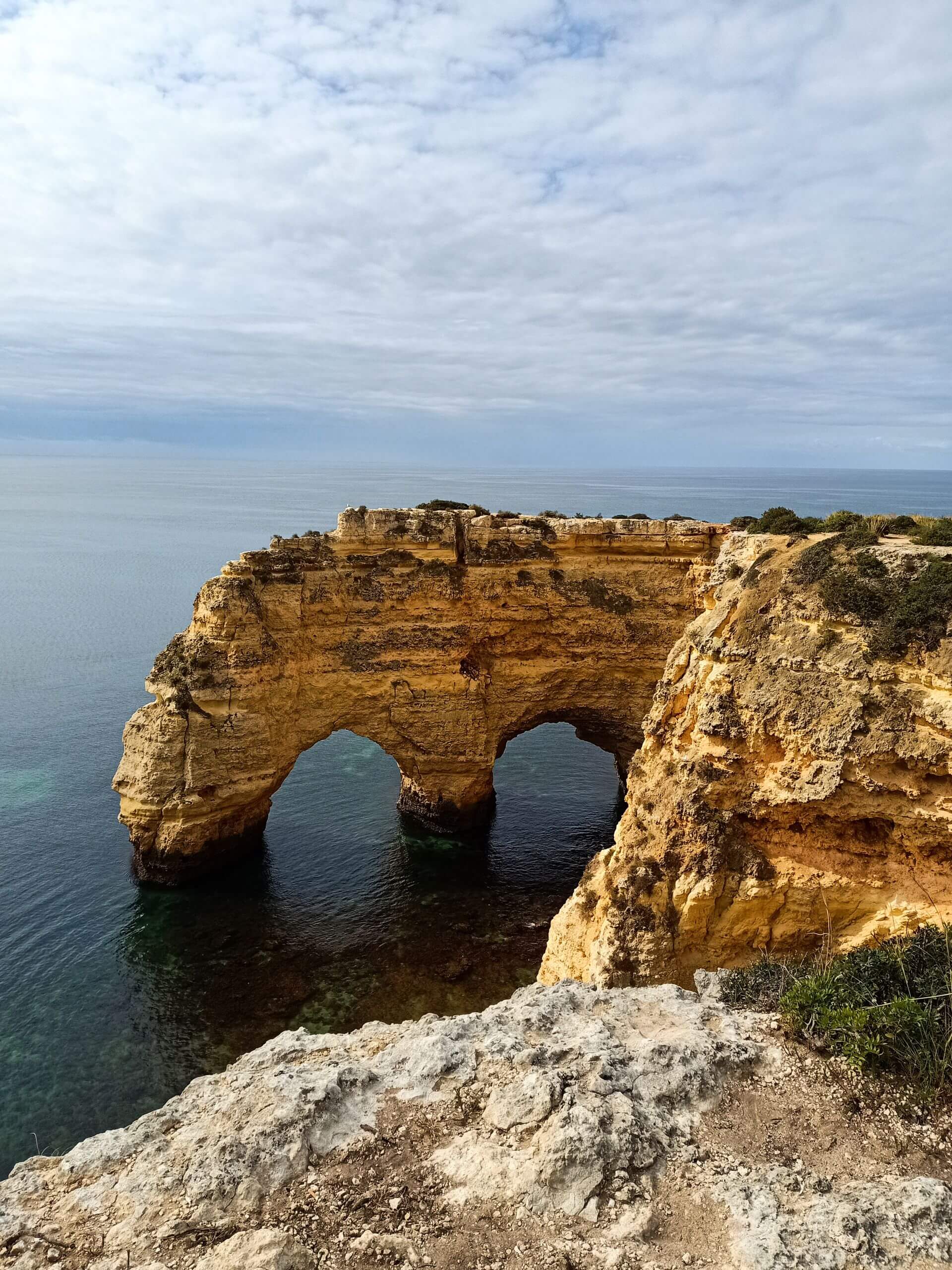 Uma cena matinal pacífica de pessoas a praticarem Qigong suave nos belos penhascos com vista para o oceano na Praia da Marinha ao nascer do sol.