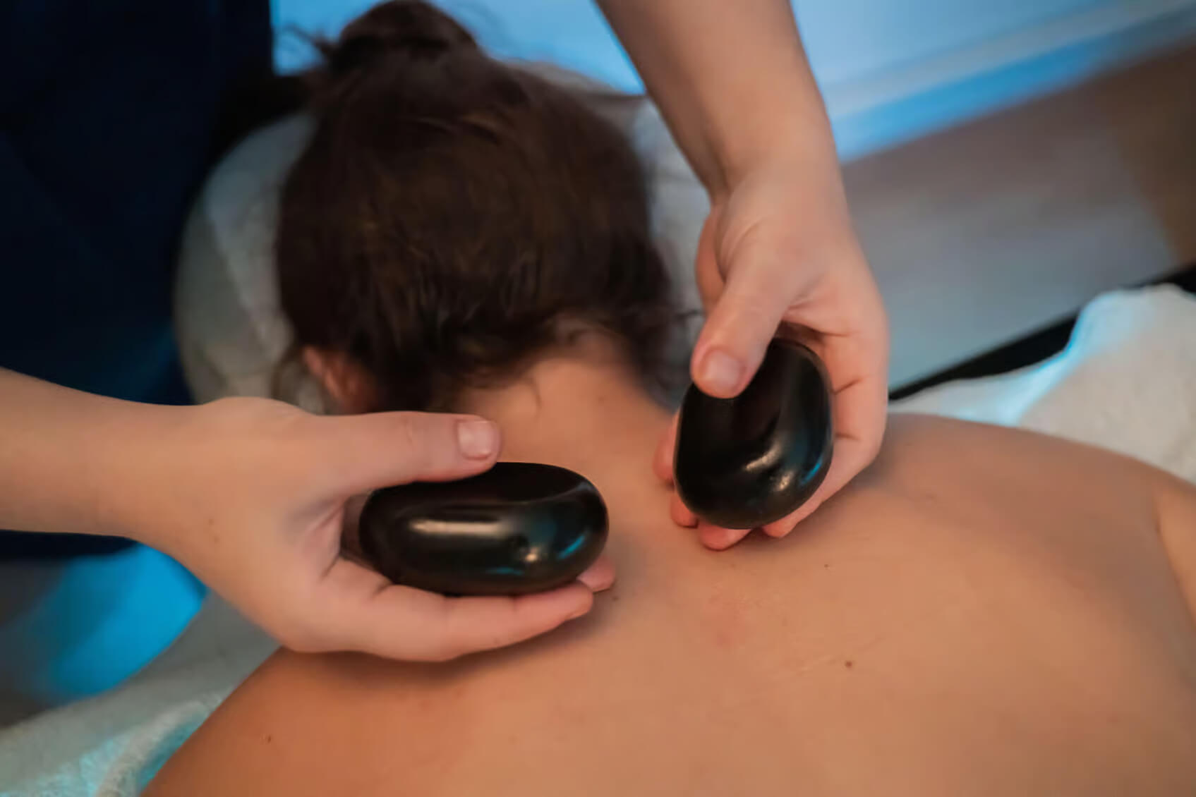 Pedras vulcânicas Açorianas suaves e aquecidas utilizadas para uma massagem terapêutica de bem-estar.
